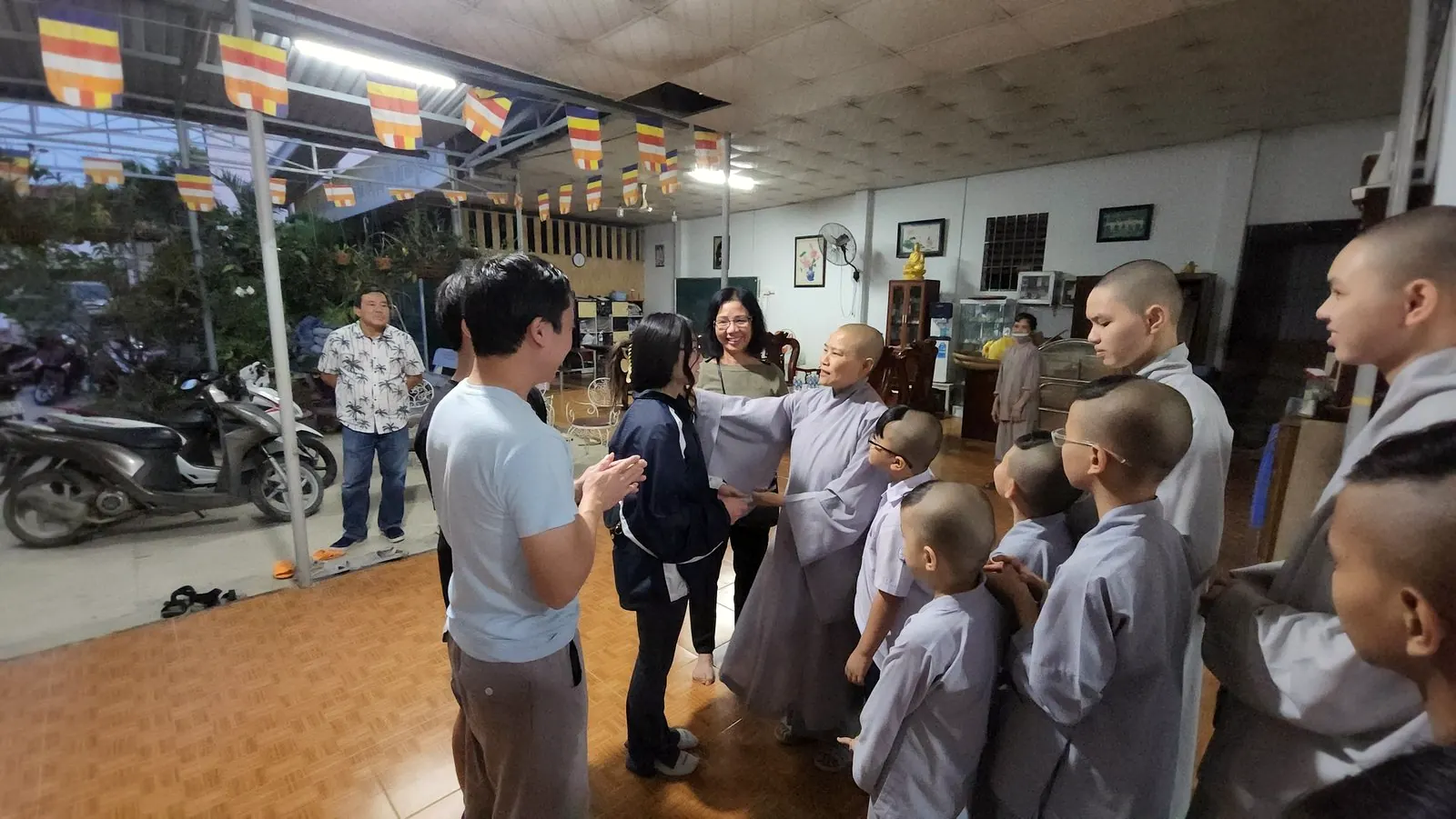 Monks and children gather with the TranScience team inside a pagoda