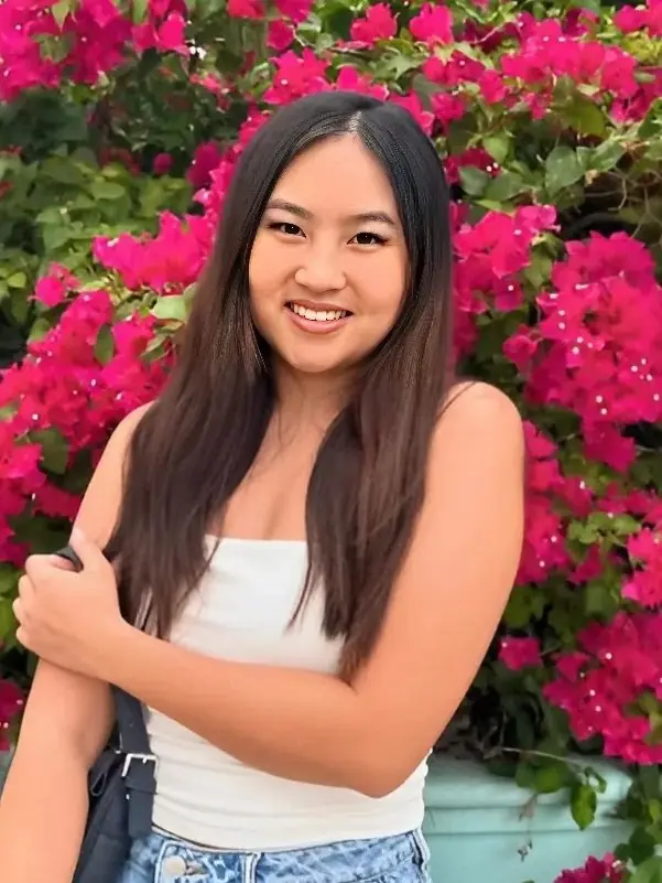 Kelli Tran standing in front of pink bougainvillea