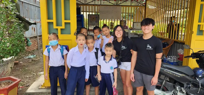 Children in school uniforms pose with Rilina and Dylan