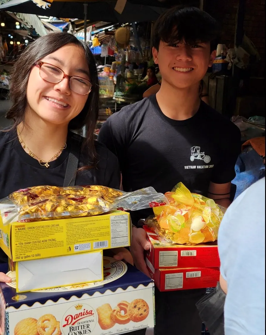 Rilina and Dylan hold bags of candy and snacks